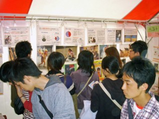 展示ブース内の写真パネルを見る人たち