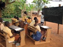 学校では教室が足りず屋外で授業を受けている生徒も