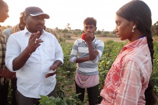 畑で働く子どもに学校に来るよう話をする様子