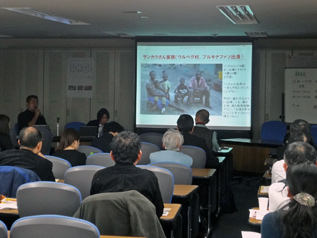 ガーナ帰国報告会で家庭訪問した家族を紹介するスタッフの近藤