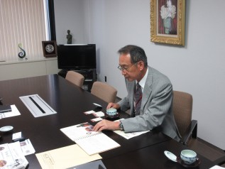 メッセージブックを手に取る新井前社長